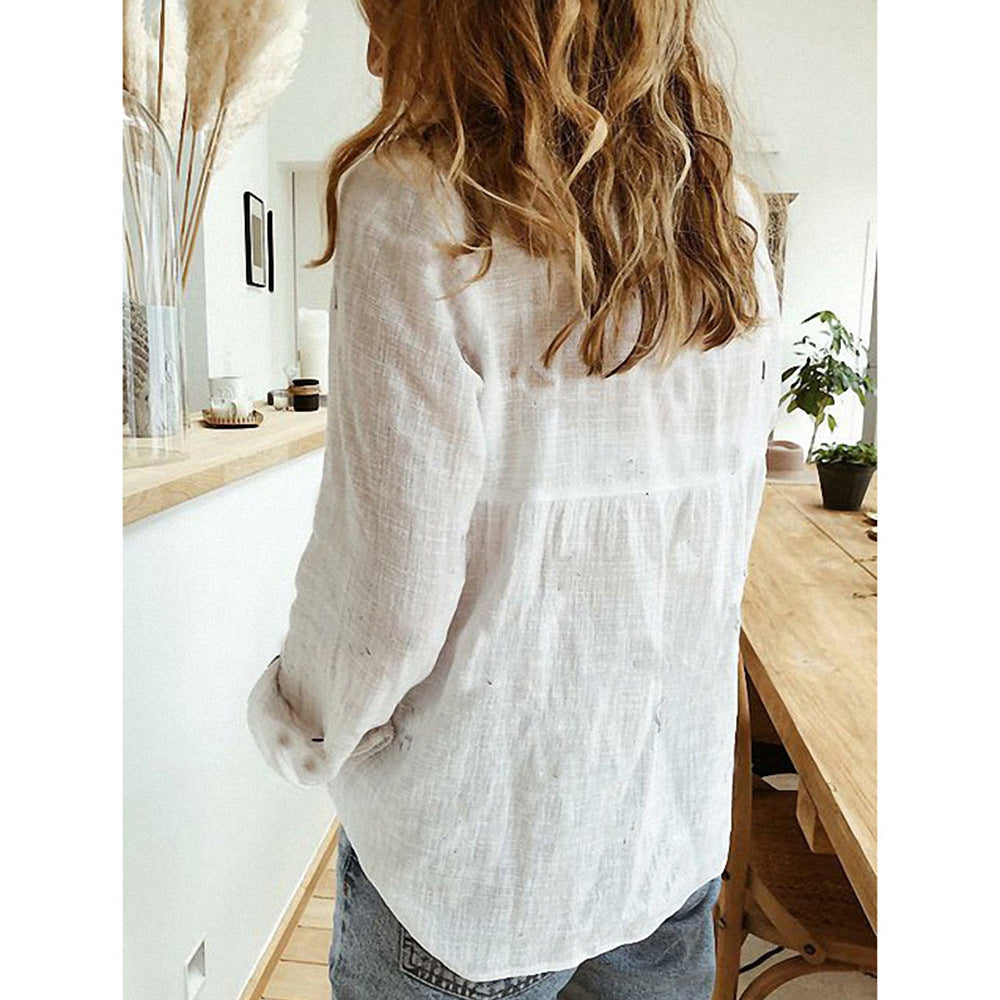 Person wearing a white blouse in a bright, minimalistic room.