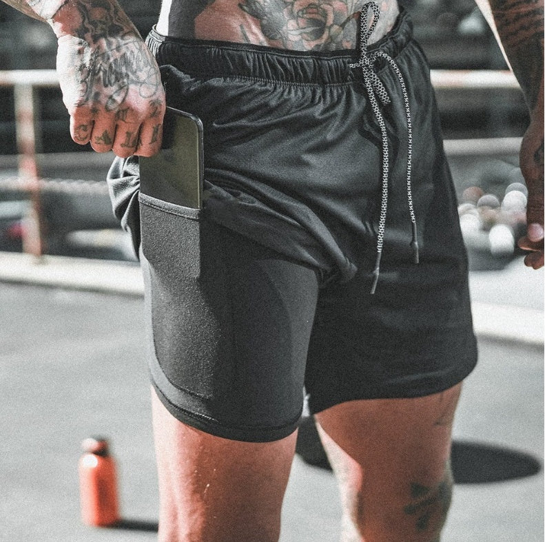 Person wearing black athletic shorts with a blurred background