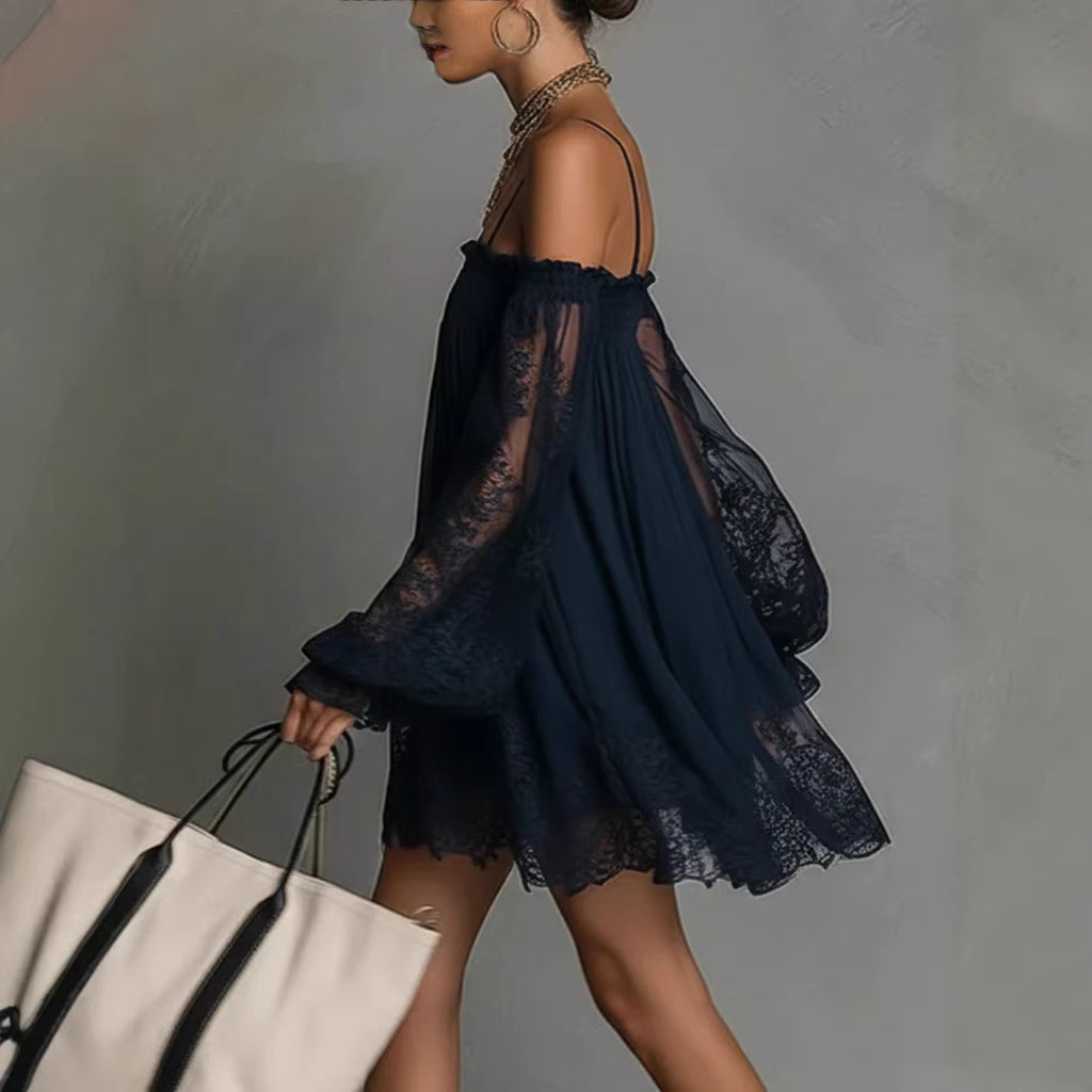 Woman wearing a dark blue lace dress holding a white tote bag against a gray background