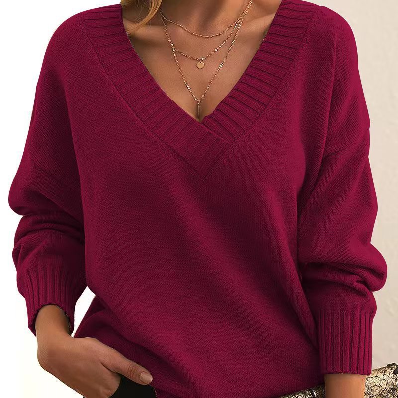 Maroon sweater worn by a person on a neutral background