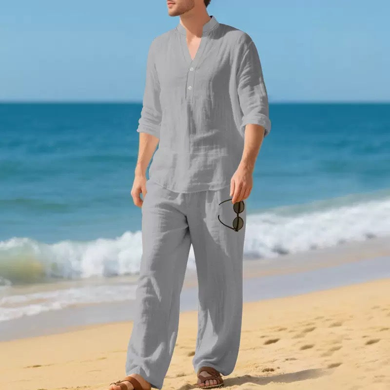 Person wearing a gray outfit on a beach with ocean waves in the background