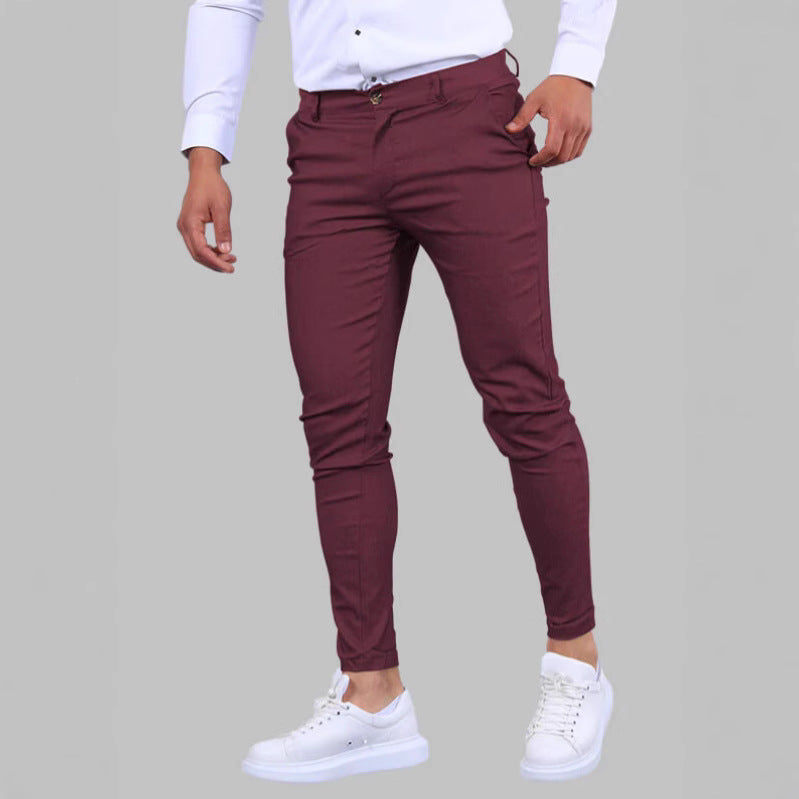 Maroon pants worn by a person on a gray background