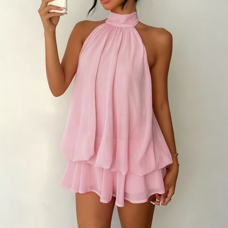 Pink halter neck dress worn by a person on a plain background
