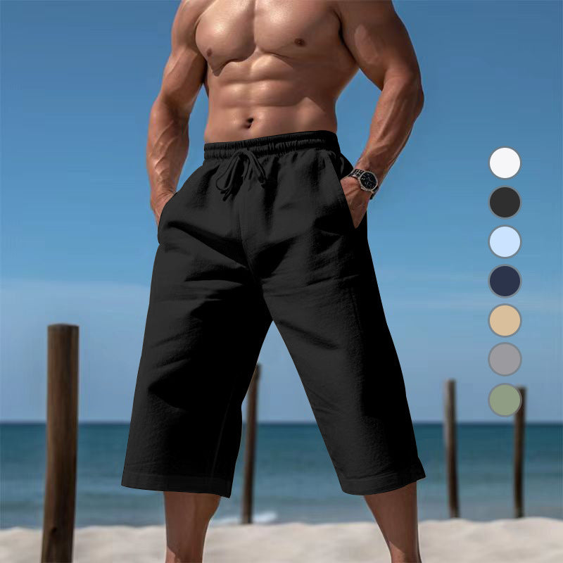 Man wearing black shorts on a beach with color swatches.