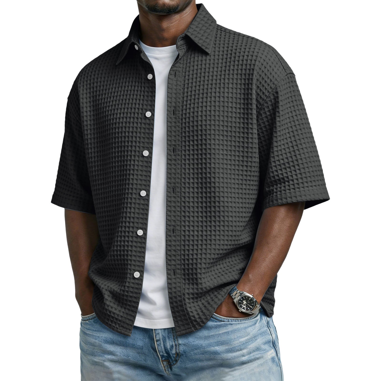 Man wearing a textured dark gray shirt over a white t-shirt with light blue jeans on a white background