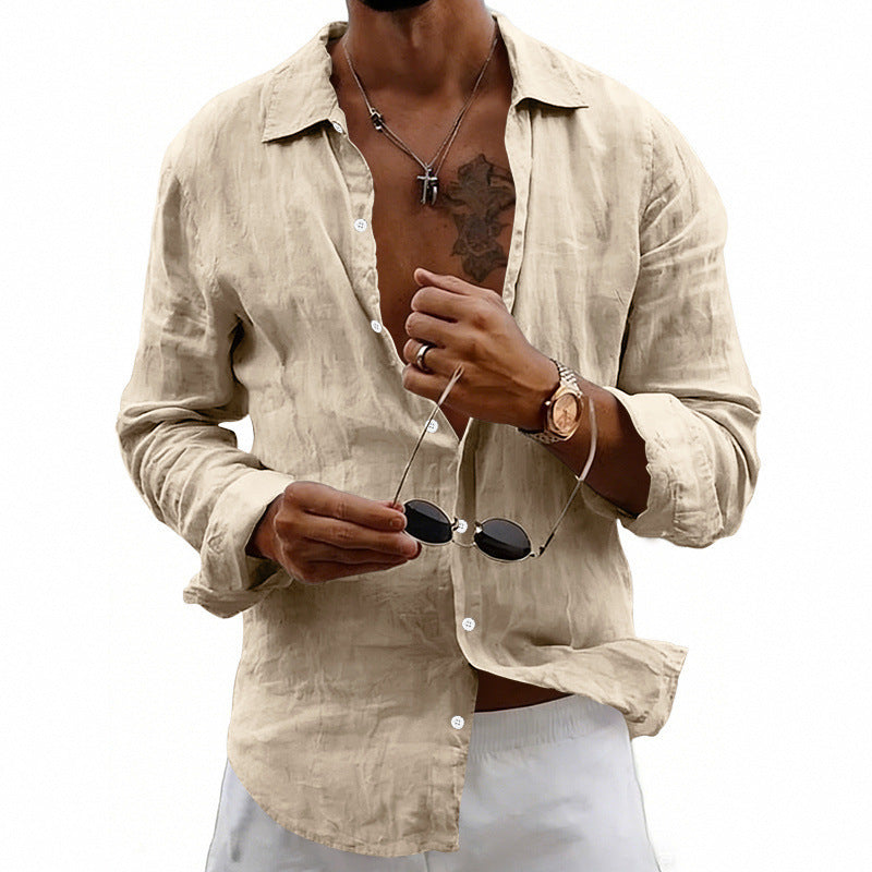 Man wearing a beige linen shirt holding sunglasses on a white background