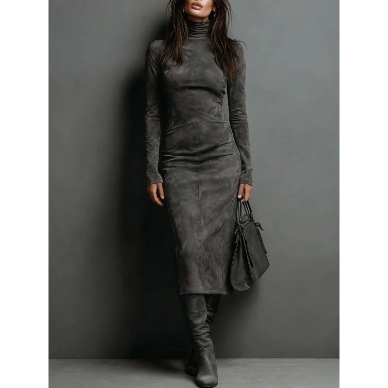 Woman wearing a gray dress and holding a matching handbag against a gray background