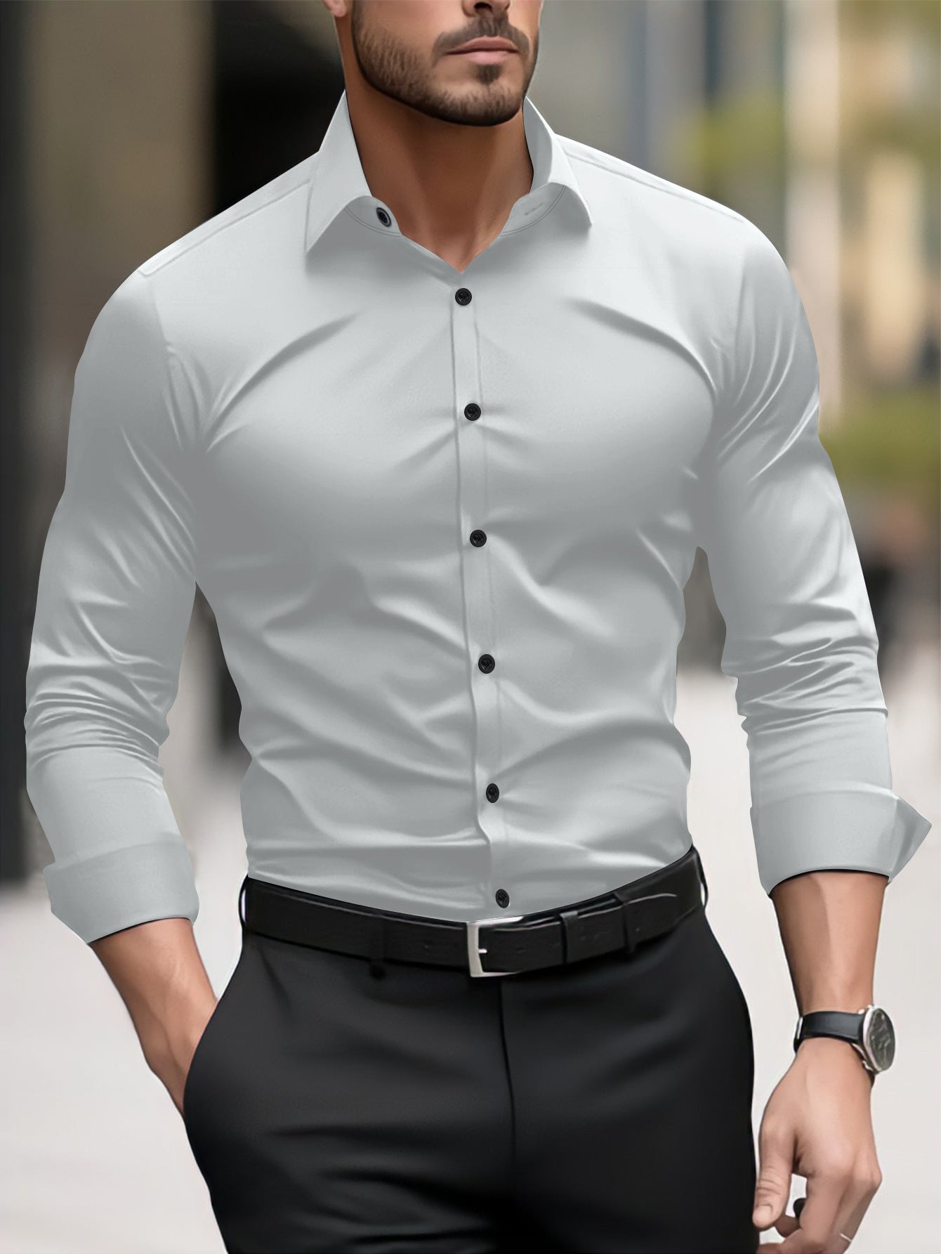 Man wearing a light gray dress shirt with black buttons and black pants in an urban setting.