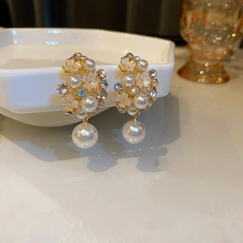 Pair of decorative earrings with pearls on a white surface