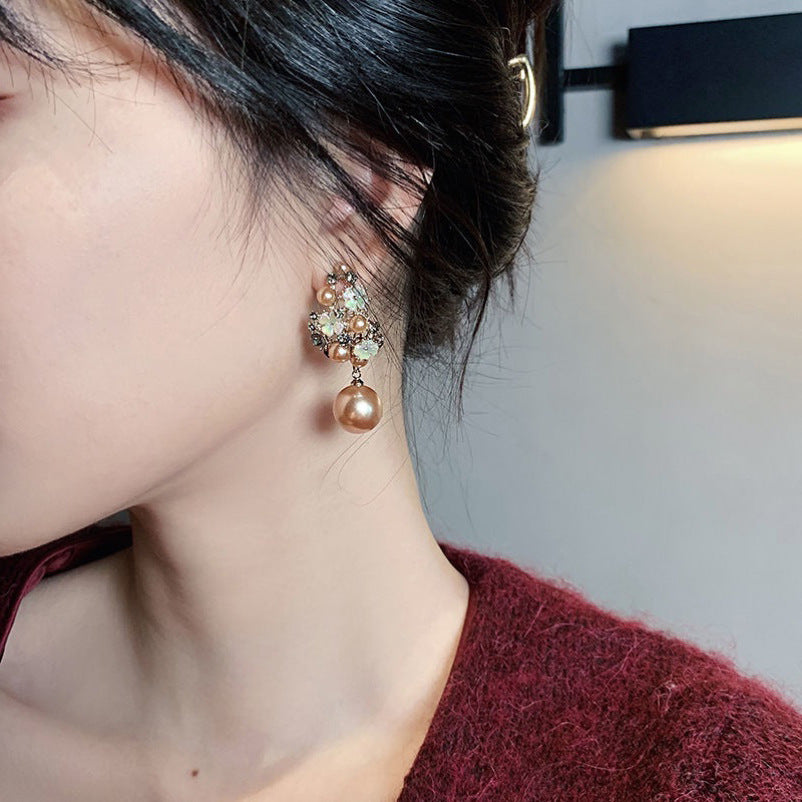 Close-up of a person wearing a pearl earring with a blurred background