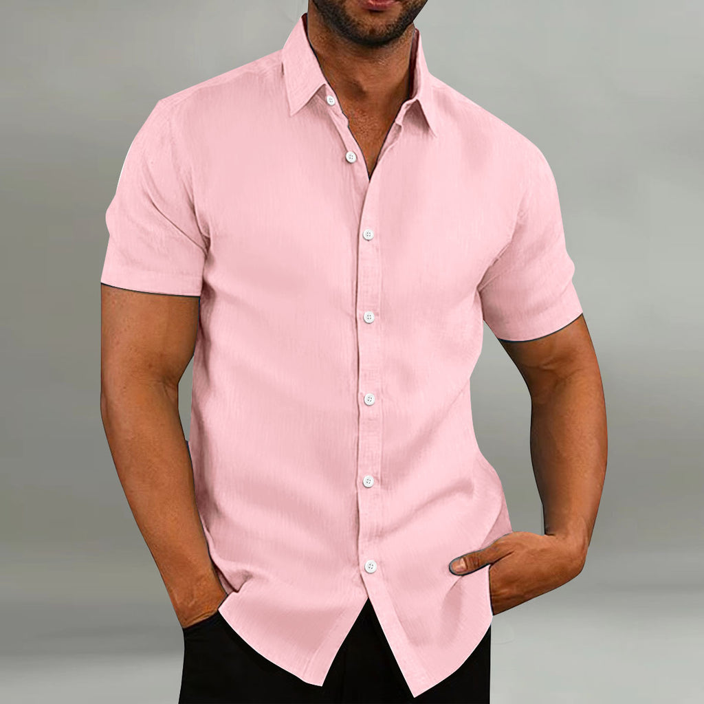 Man wearing a pink short-sleeve shirt against a gray background