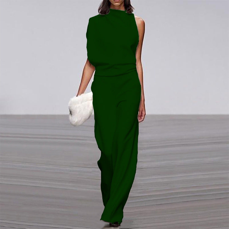 Woman wearing a green dress holding a white fur bag on a gray floor.