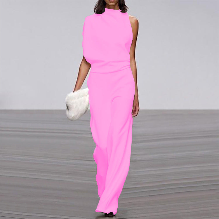 Woman wearing a bright pink jumpsuit on a gray background