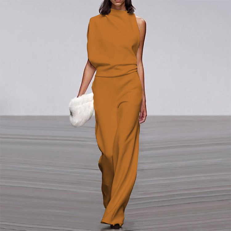 Woman wearing a mustard yellow jumpsuit on a gray floor.