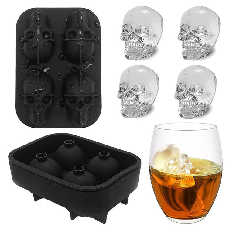 Skull-shaped ice cube tray with clear skull ice cubes and a glass of whiskey with an ice cube.