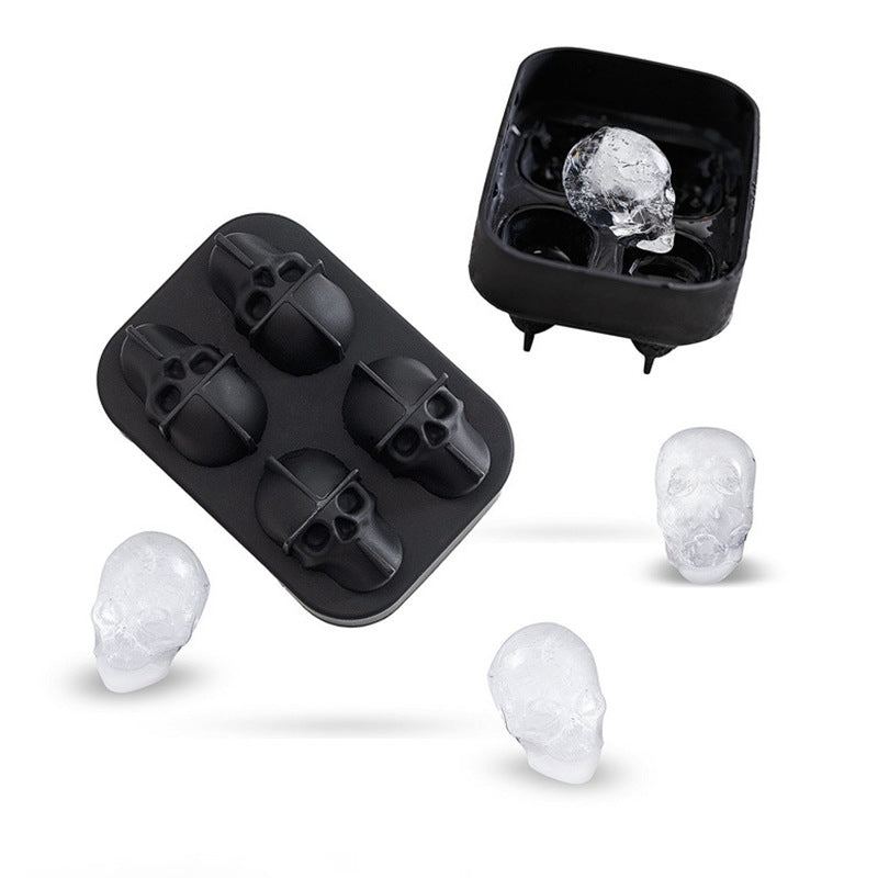 Black skull-shaped ice cube tray with freshly formed ice cubes on a white background