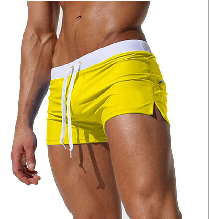 Yellow swim shorts with white drawstring on a white background