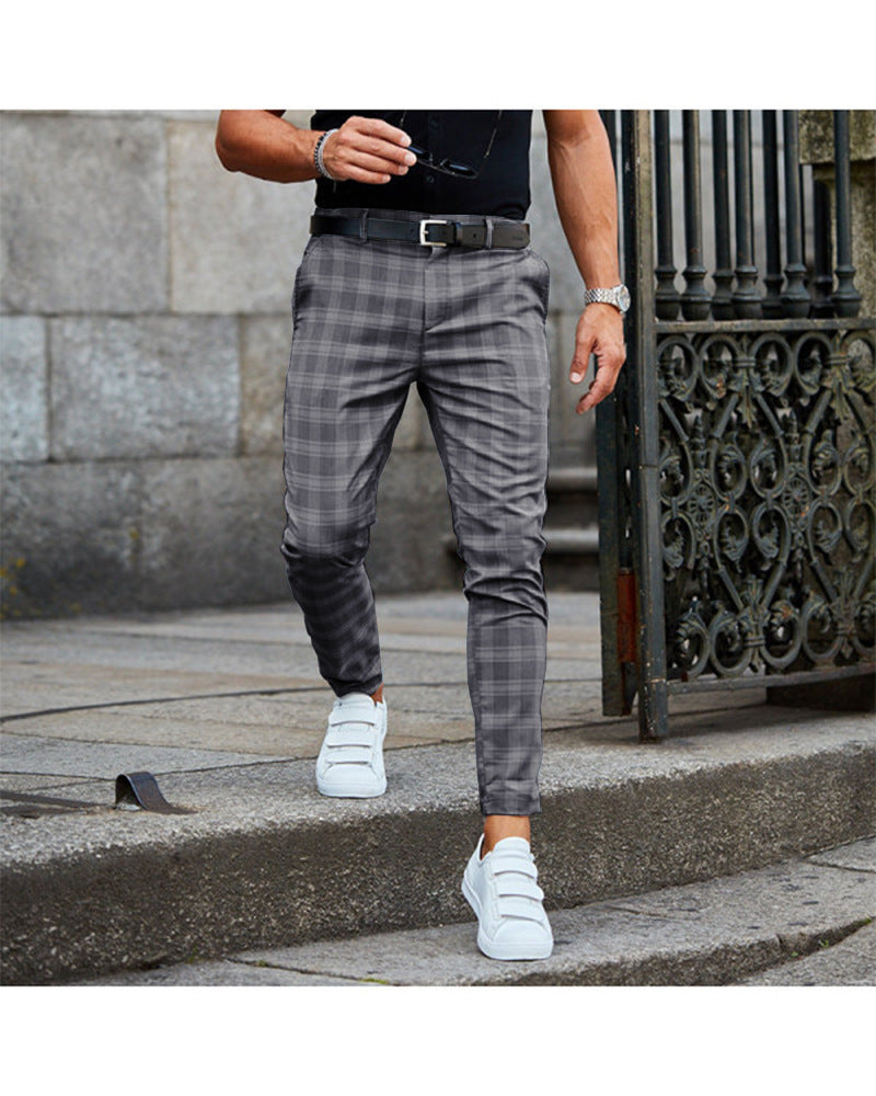 Person wearing plaid pants and white sneakers on a stone staircase.