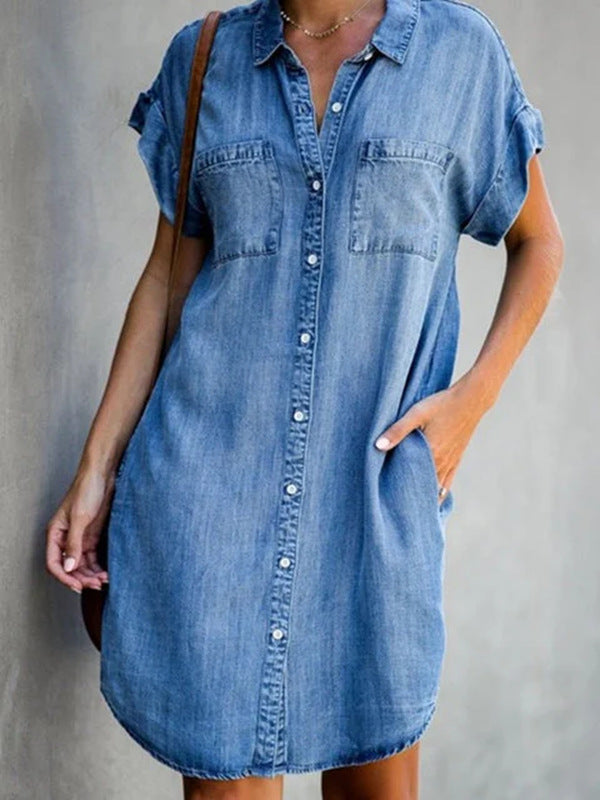 Person wearing a denim dress against a gray background