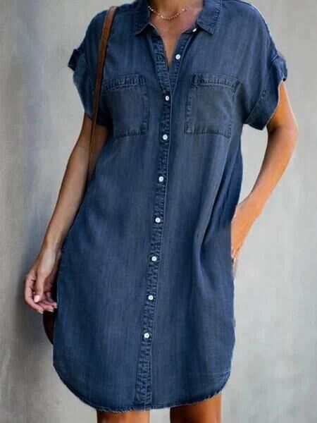 Person wearing a blue denim dress against a gray background