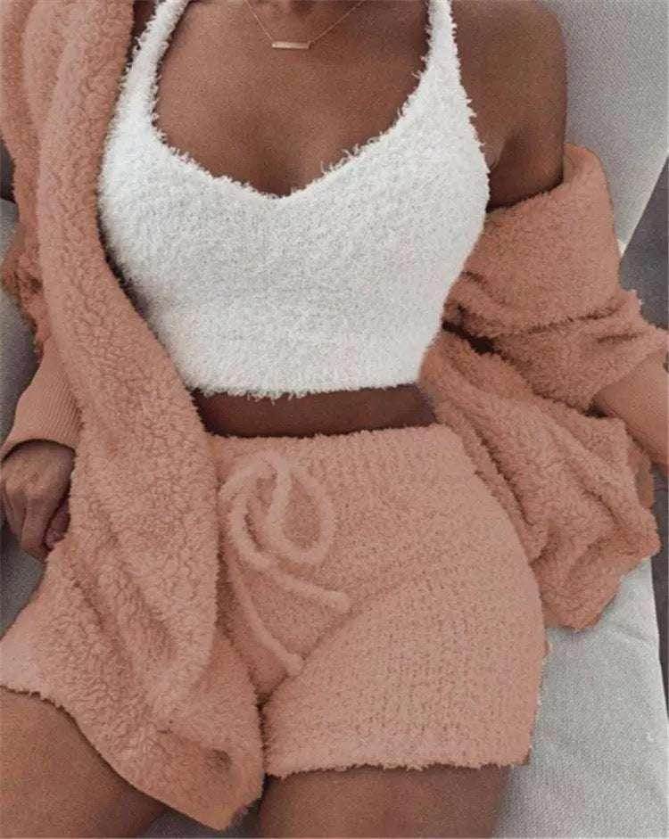 Woman wearing cozy ZA-Zola loungewear set with fluffy white crop top and peach shorts.