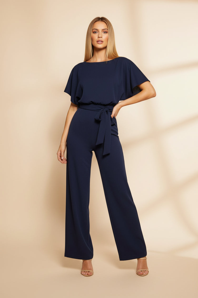 Woman wearing a navy blue jumpsuit on a white background