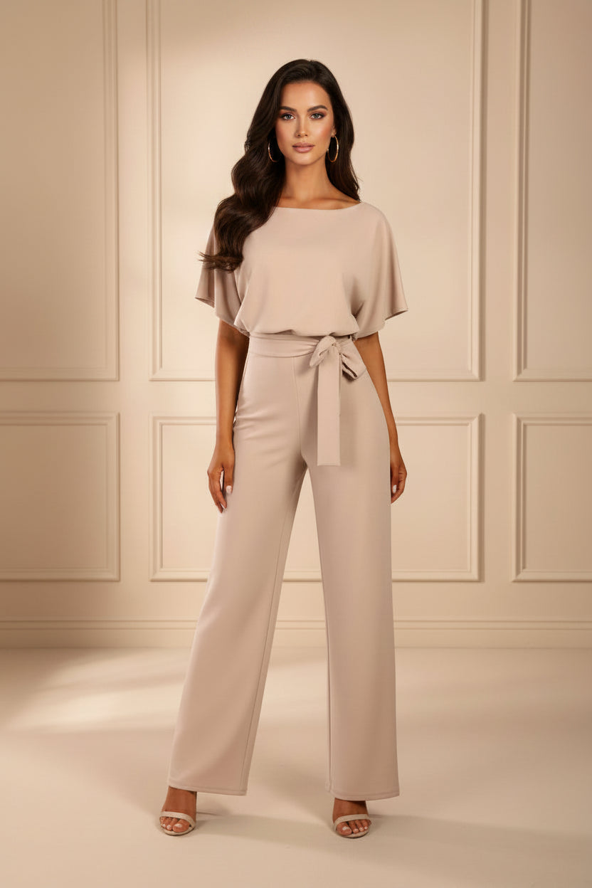 Woman wearing a beige outfit with a plain background