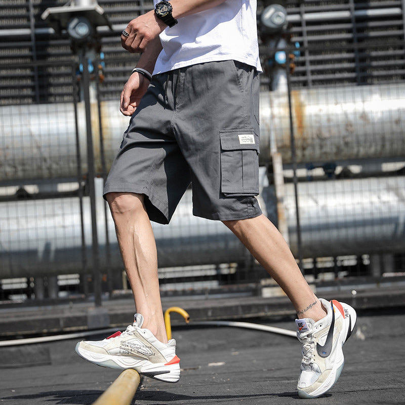 Person wearing gray cargo shorts and white sneakers in an urban setting