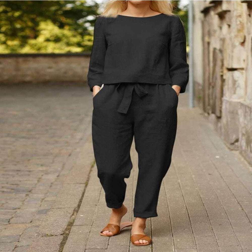 Woman wearing a chic black linen outfit with tie waist pants from ZA-Zola, walking outdoors