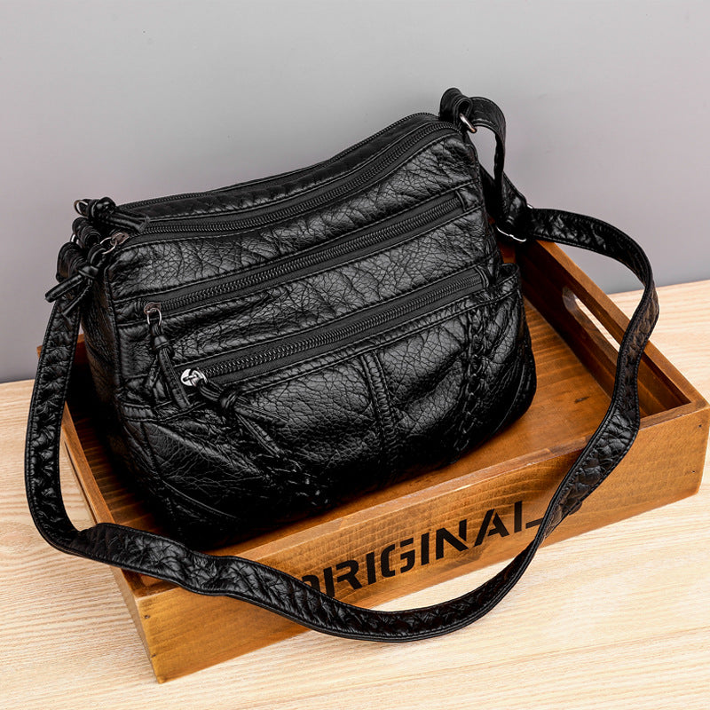 Black textured handbag on a wooden tray with 'ORIGINAL' branding.