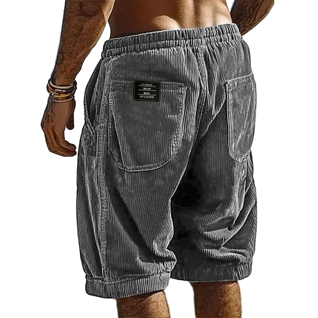 Gray corduroy shorts worn by a person on a white background