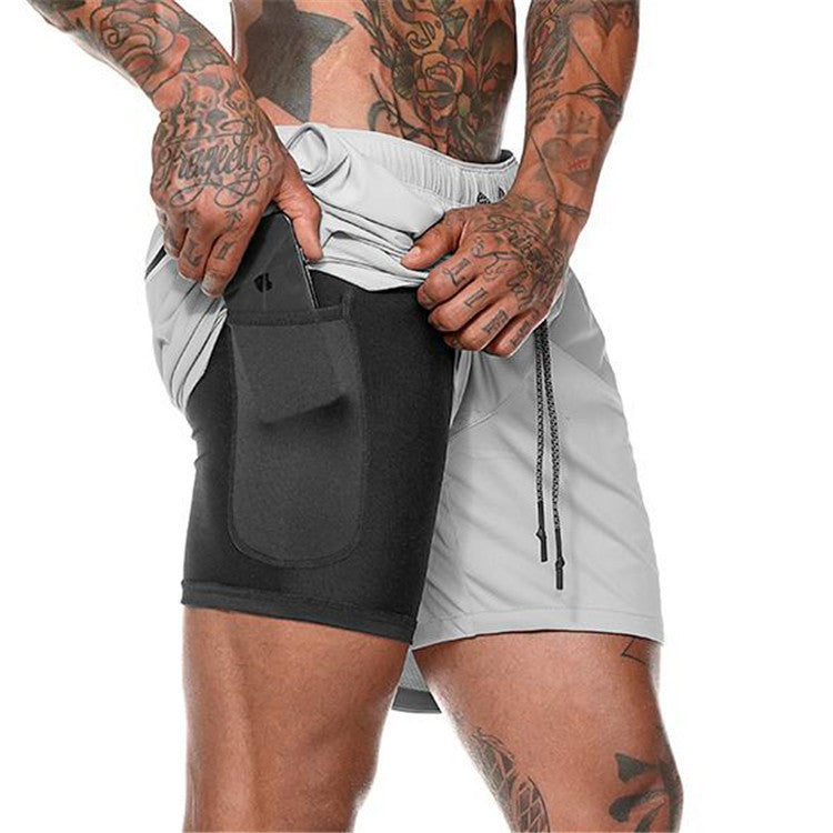 Person wearing a black and gray athletic shorts with a pocket on a white background