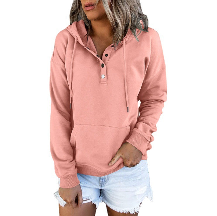 Woman wearing a pink hoodie and denim shorts on a plain background