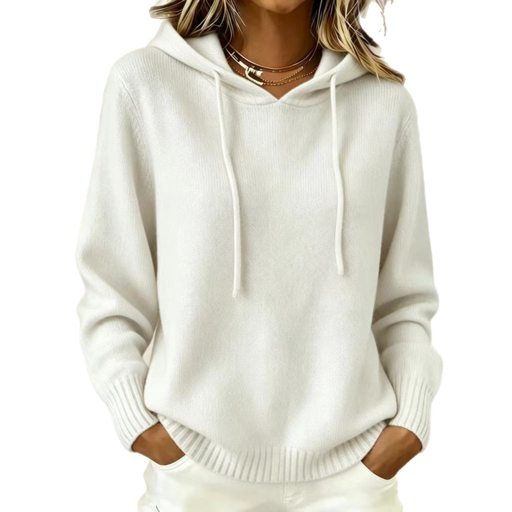A woman wearing a cream-colored ribbed knit hoodie with drawstrings and long sleeves, shown from the neck down against a plain white background.