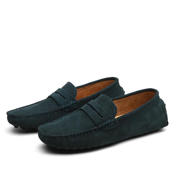Pair of dark green loafers on a white background