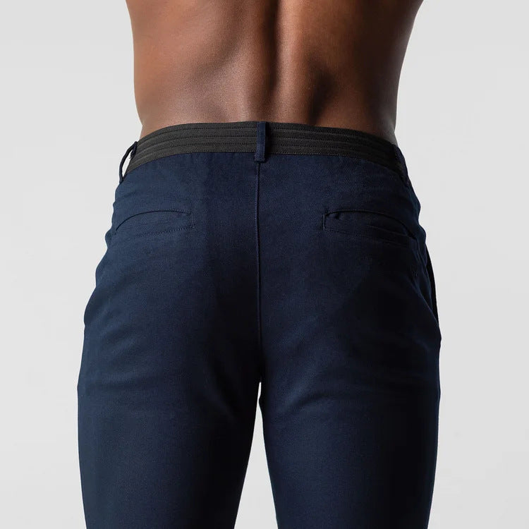 Navy blue pants worn by a person on a plain background