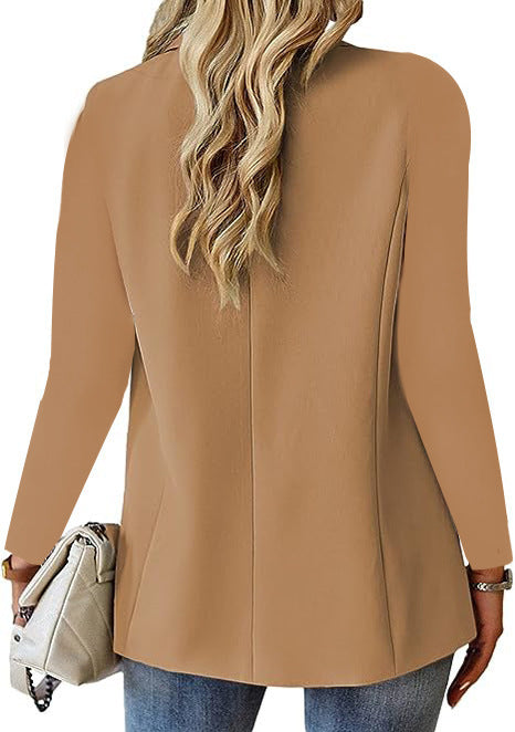Person wearing a beige blazer with a white background