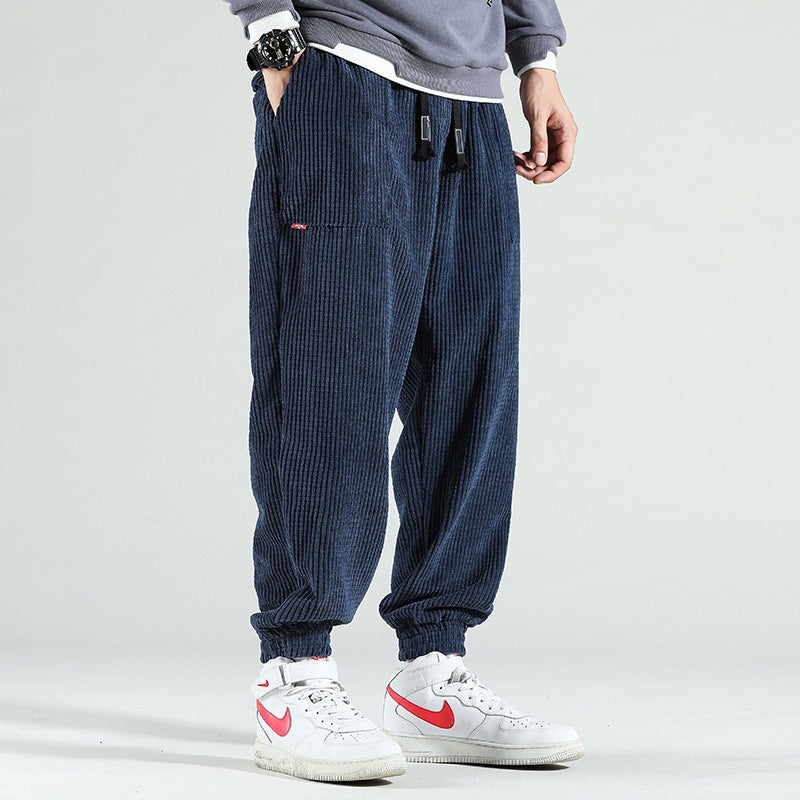 Person wearing blue corduroy pants with a plain background