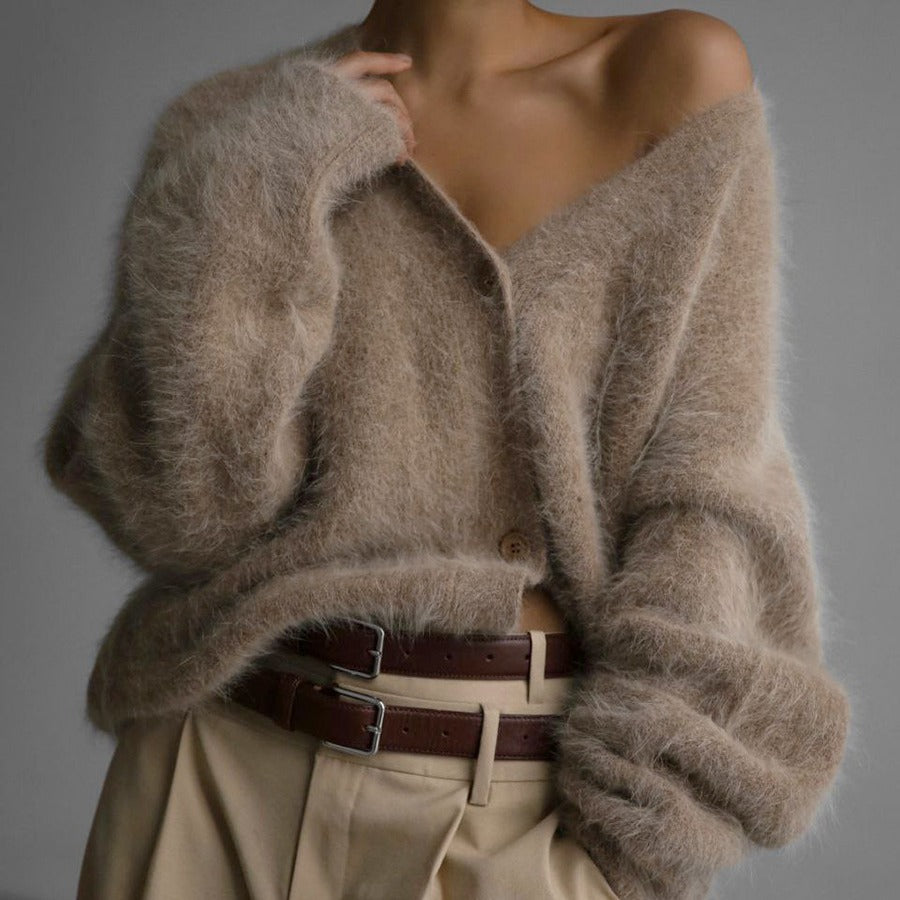 Mannequin wearing a beige cardigan with a belt against a gray background