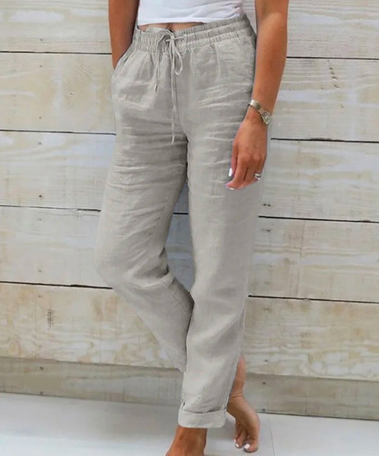 Person wearing light gray pants with a wooden background