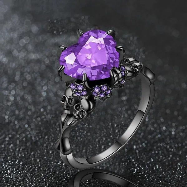 Ring with purple gem and skull design on a dark background