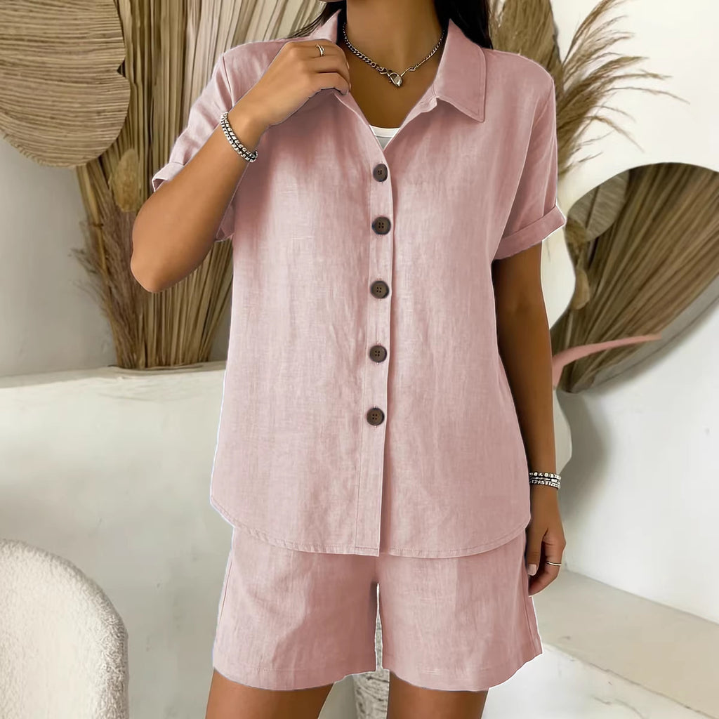 Person wearing a pink linen outfit with buttons in a minimalistic setting.