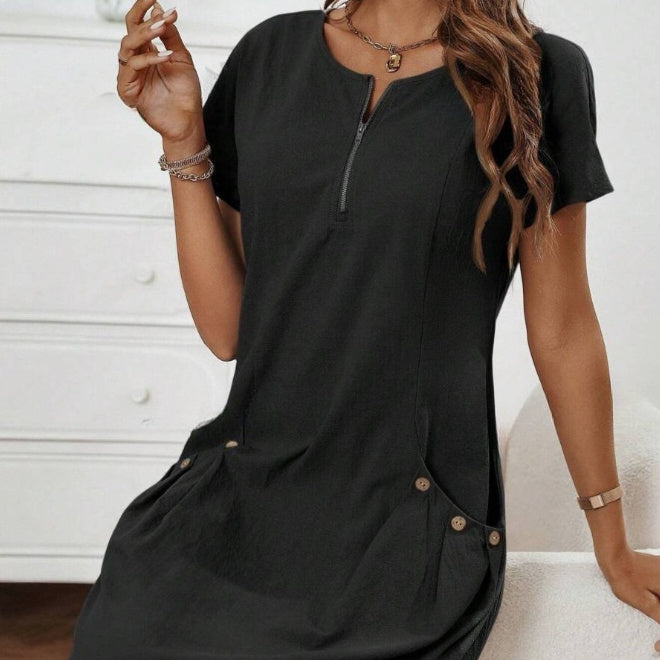 Person wearing a black dress with a zipper detail against a white background