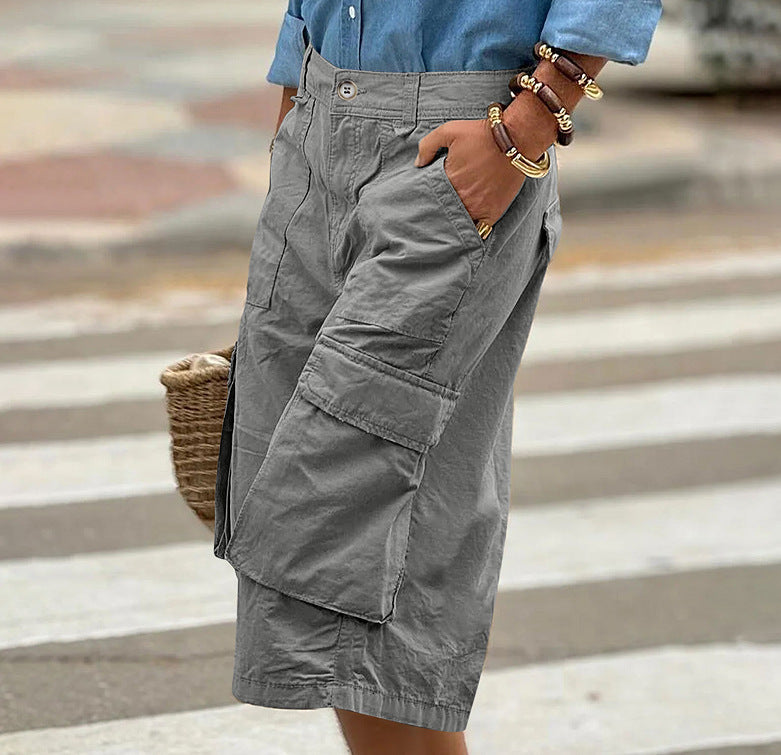 Person wearing gray cargo shorts with a blurred background