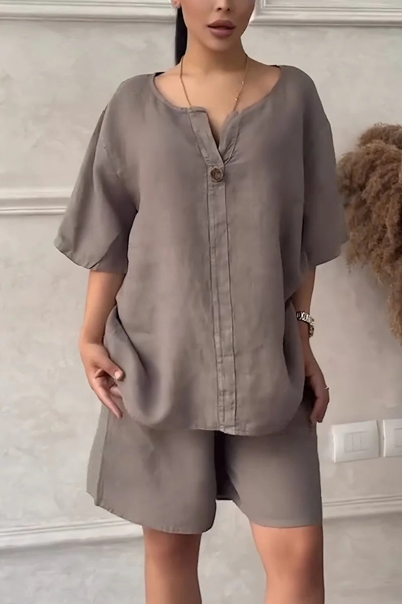 Woman wearing a gray outfit with a plain background