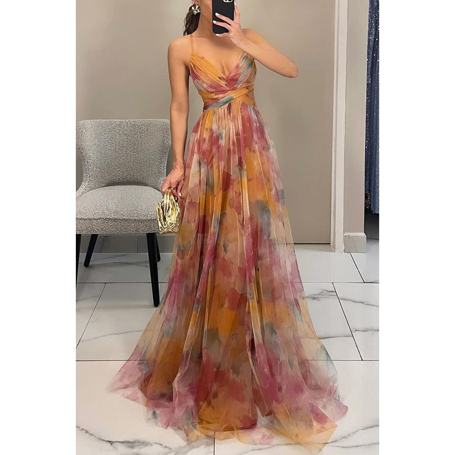Woman wearing a colorful floral dress taking a mirror selfie in an indoor setting.