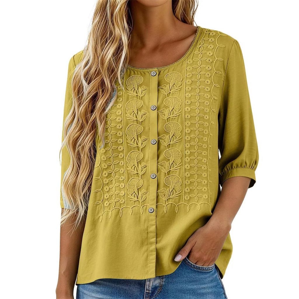 Yellow embroidered blouse worn by a person on a white background