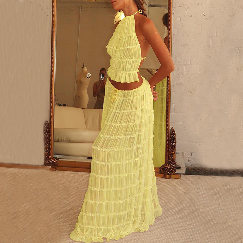 Woman wearing a yellow dress standing in front of a mirror.
