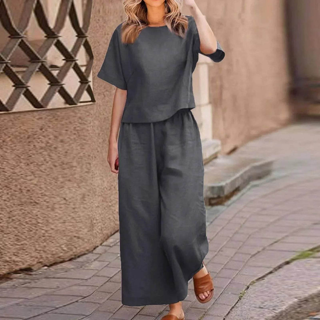 Woman wearing a dark grey linen set with wide-leg pants from ZA-Zola, walking outdoors.