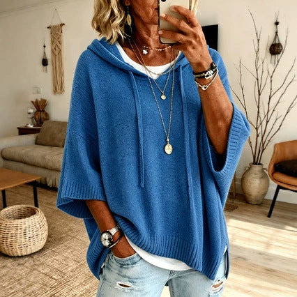 Person wearing a blue poncho in a living room setting
